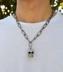 Colar corrente larga de metal com caveira pendente. Este colar é curto e possui fecho mesquetão com terminal de corrente ajustável. 