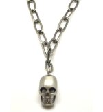 Colar corrente larga de metal com caveira pendente. Este colar é curto e possui fecho mesquetão com terminal de corrente ajustável. 