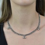 Colar berloques boho style. Colar curto prateado com aplicações em metal e corrente com fecho ajustável.